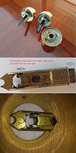 Knob has crescent-shaped bar which pulls back latch bolt when turned. Version on upper right has a lock; version on upper left does not. Kwikset uses this shape. Other companies have square or D-shaped bars.